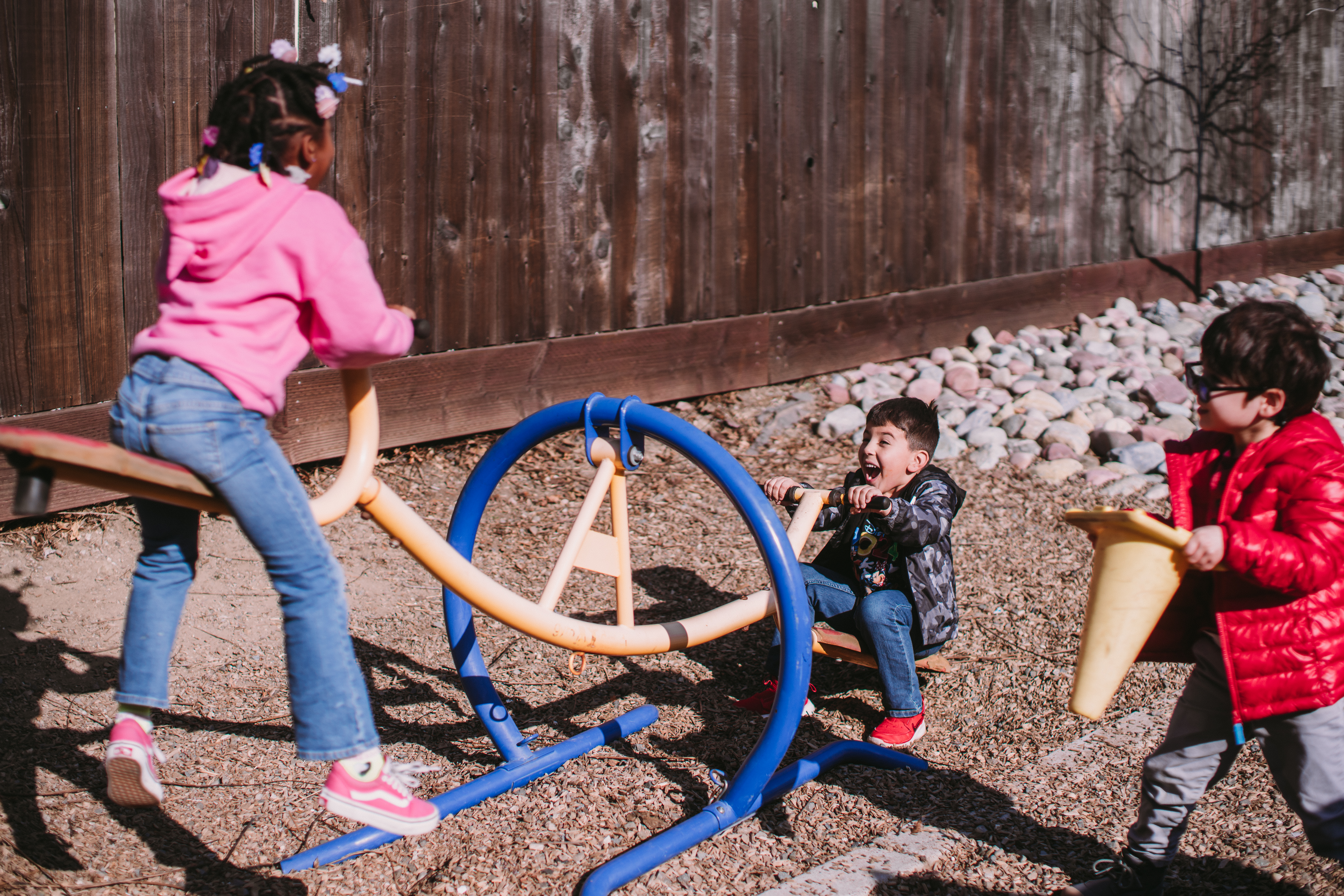 Two students playing on a teeter totter.